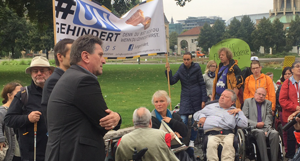 Sozial- und Integrationsminister Manne Lucha hört einer Demonstrantin zu