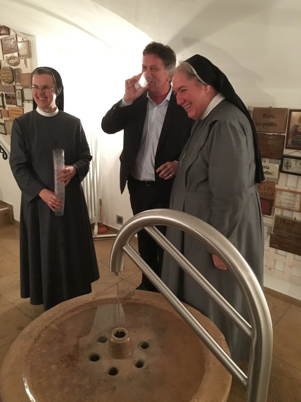 Minister Manne Lucha trinkt aus Quelle im Kloster Heiligenbronn