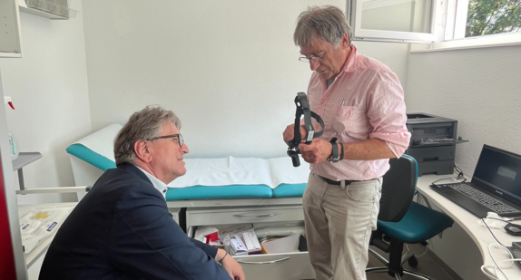 Ein Betreuer des Projekts A.B.B.A. zeigt Minister Manne Lucha in einem Behandlungsraum, wie Menschen mit medizinischen Problemen versorgt werden können auch wenn sie keine Krankenversicherung haben.