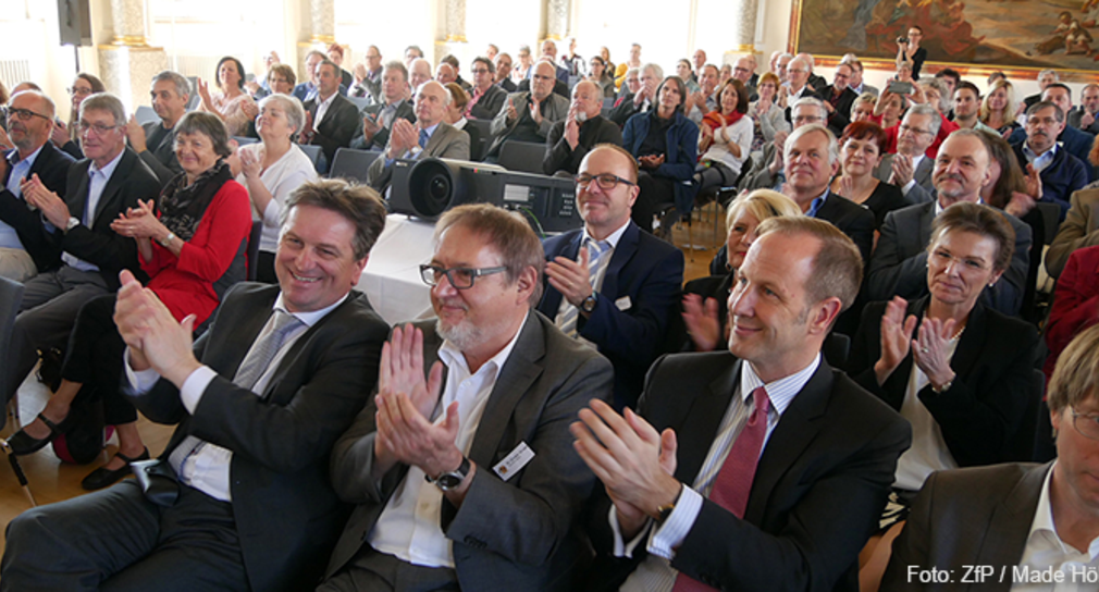 Minister Manne Lucha, Dr. Dieter Grupp (Geschäftsführer ZfP Südwürttemberg) und Dr. Daniel Rapp (Oberbürgermeister der Stadt Ravensburg) sitzen in Publikum und klatschen Beifall