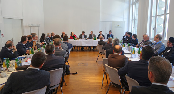Minister Manne Lucha und die Teilnehmenden des Runden Tischs der Religionen sitzen am 24. Mai 2017 in Stuttgart an einem Konferenztisch