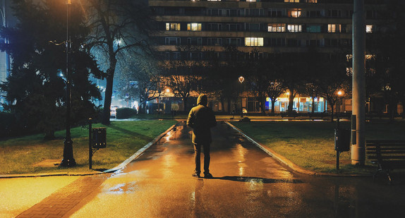 Mensch steht nachts allein in Park