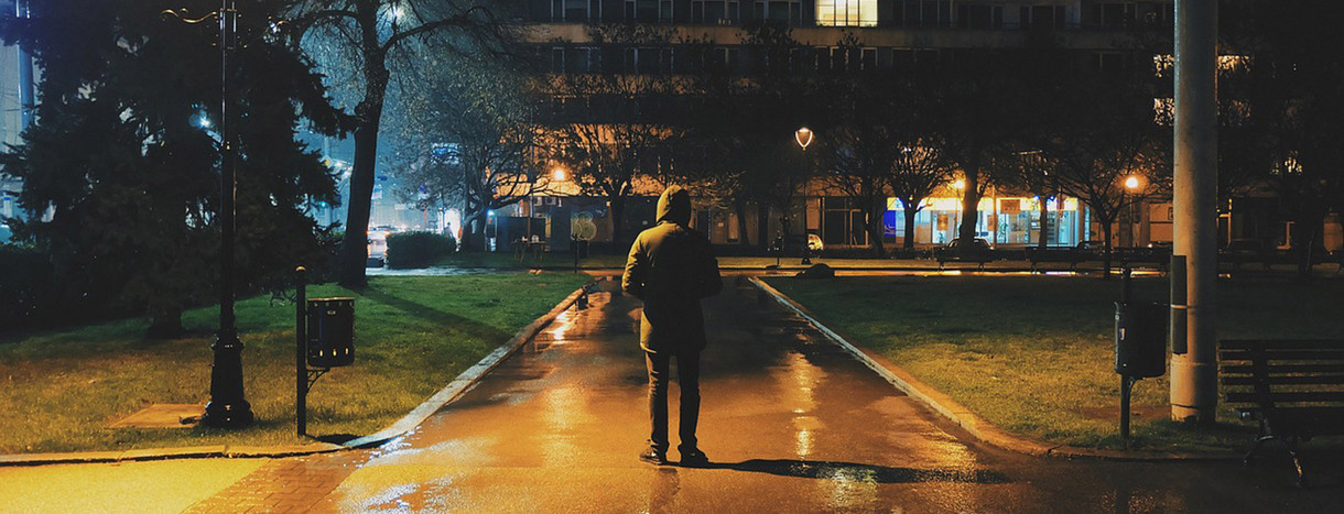 Mensch steht nachts allein in Park