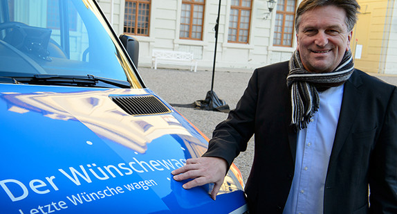 Schirmherr Minister Manne Lucha steht vor dem neu eingeweihten „Wünschewagen“ in Ludwigsburg (Foto: Sina Schuldt/dpa)