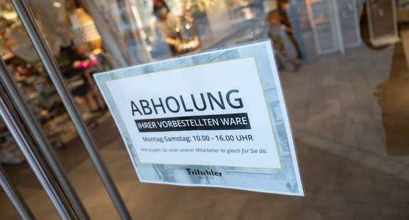Ein Schild mit der Aufschrift „Abholung“ hängt am Eingang eines Haushaltswarengeschäfts.