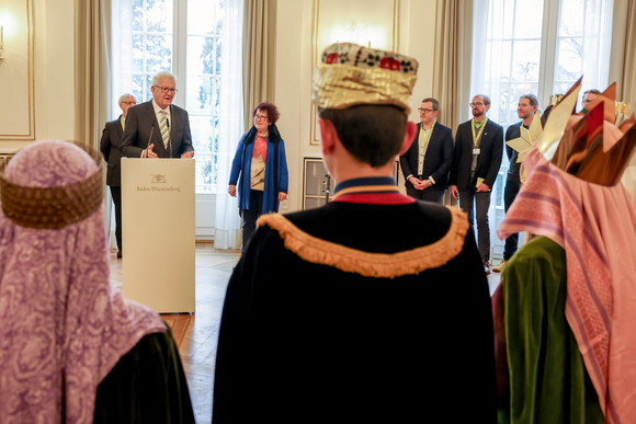 Aktion Dreikönigssingen Kretschmann empfängt Sternsingergruppen Ministerpräsident Winfried Kretschmann (hinten links) spricht zu den Sternsingerinnen und Sternsingern.