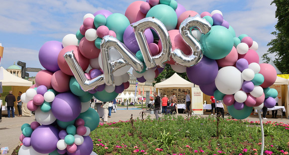 Bunte Luftballons-Girlande mit Schriftzug „LADS“ an einem Rundbogen.