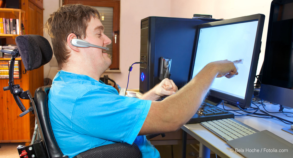 Mann mit celebraler Bewegungsstörung bedient Computer