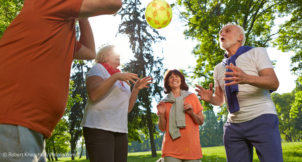 Gruppe von älteren Menschen spielt mit Ball