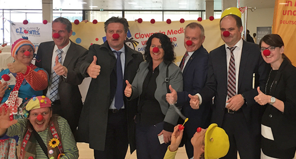 Minister Manne Lucha (4. v. l.) am Stand des Dachverbandes „Clowns in Medizin und Pflege“ im Stuttgarter Landtag (Quelle: Ministerium für Soziales und Integration Baden-Württemberg).