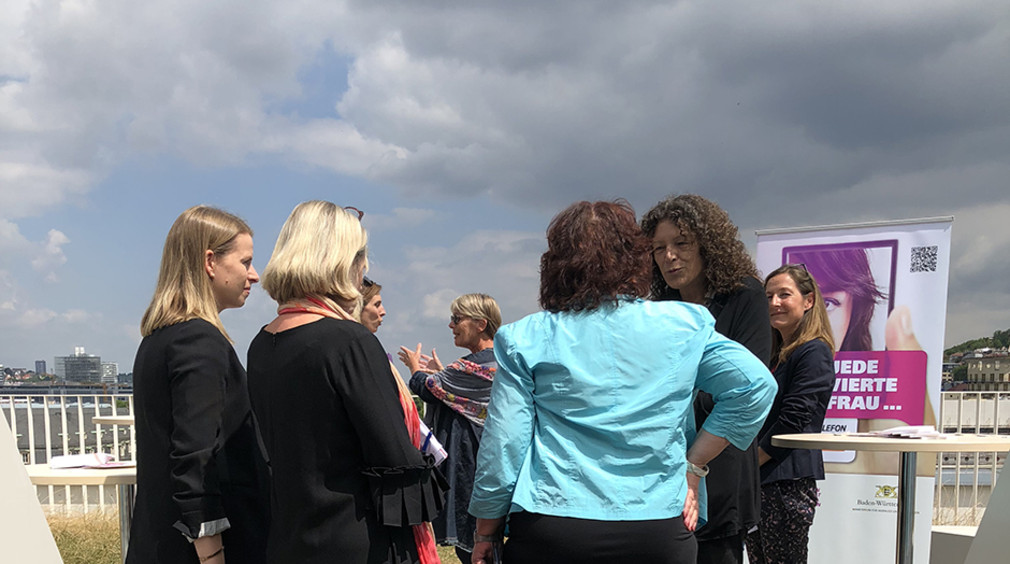Staatssekretärin Bärbl Mielich im Gespräch mit Teilnehmenden der Aktion „Jede vierte Frau“ auf der Terrasse des Sozialministerium Baden-Württemberg