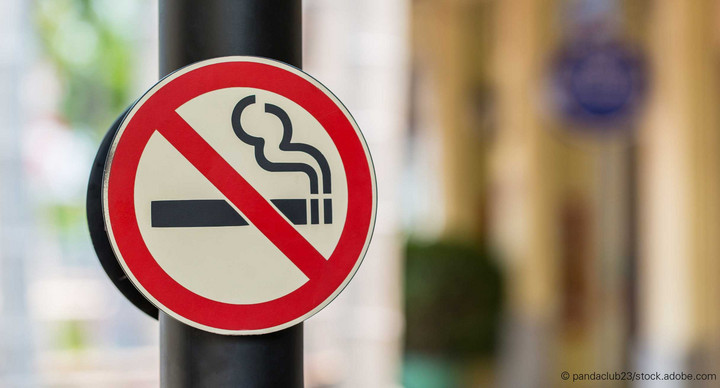 An einer Eingangstür hängt ein Schild, auf dem eine durchgestrichene Zigarette abgebildet ist. In diesem Gebäude herrscht also Rauchverbot.