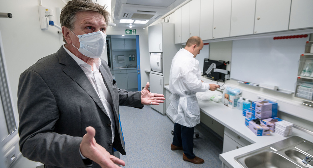 Gesundheitsminister Manne Lucha steht in einer Covid-19-Teststation in der Nähe des Stuttgarter Hauptbahnhofs, im Hintergrund steht ein Arzt. (Bild: © picture alliance/Marijan Murat/dpa)