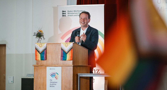 Sozialminister Oliver Hildenbrand an Redepult in einem Veranstaltungssaal.