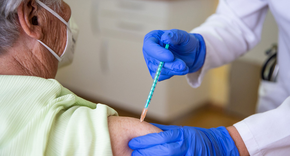 Ärztin impft in ihrer Praxis eine Patientin gegen das Coronavirus.