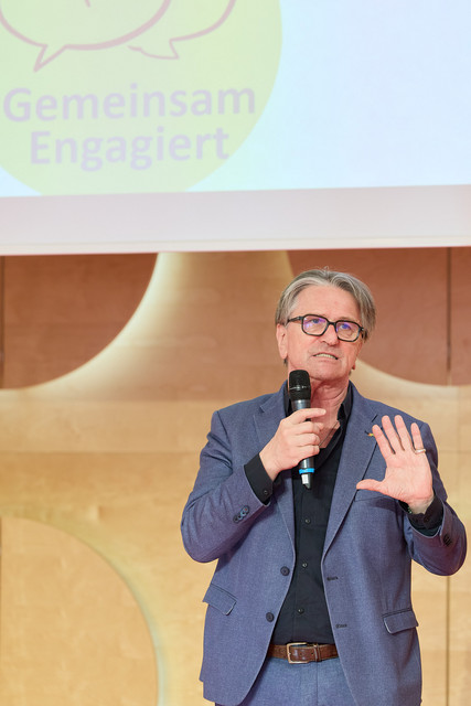 Gesundheitsminister Manne Lucha spricht auf Bühne vor Publikum.