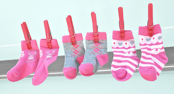 Drei Paar Babysocken auf einer Wäscheleine
