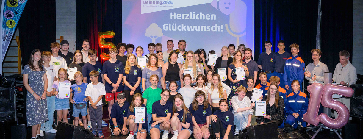 Gruppenfoto aller Preisträger des Jugendbildungspreises DeinDing 2024 auf der Bühne des Stuttgarter Jugendhauses Cann