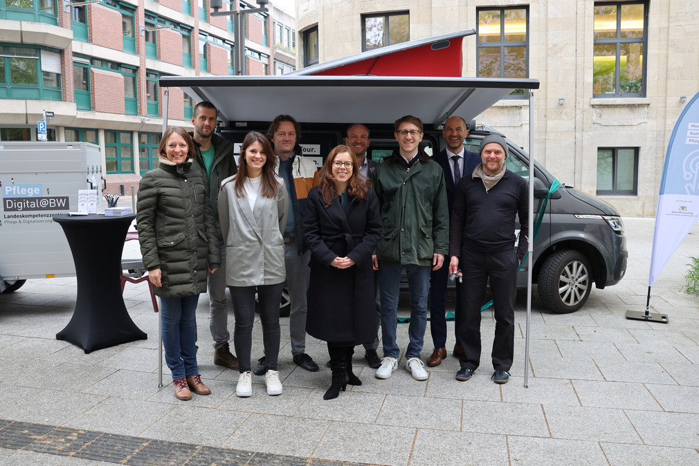 Gruppenbild im Freien vor Transfermobil: Ministerialdirektorin Leonie Dirks und das Team von PflegeDigital@BW.