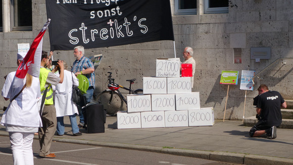 Zu einer Pyramide aufgestapelte, mit Zahlen beschriftete Kisten vor dem Haupteingang des Sozial- und Integrationsministeriums