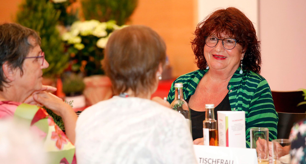 Staatssekretärin Bärbl Mielich unterhält sich bei einer Veranstaltung mit anderen Gästen.