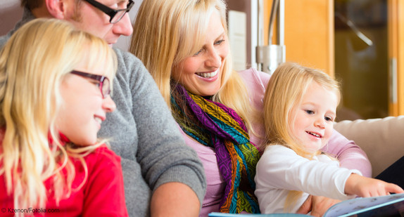 Familie beim Vorlesen auf Sofa