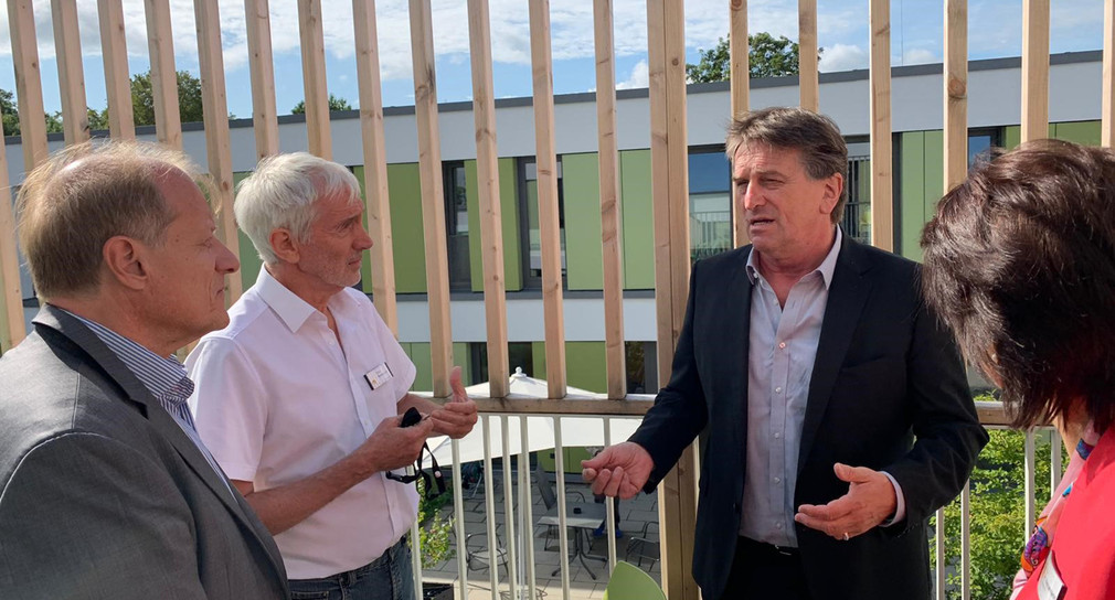 Minister Manne Lucha unterhält sich mit Mitarbeiten der Therapeutischen Wohngruppe Ehingen auf Terrasse