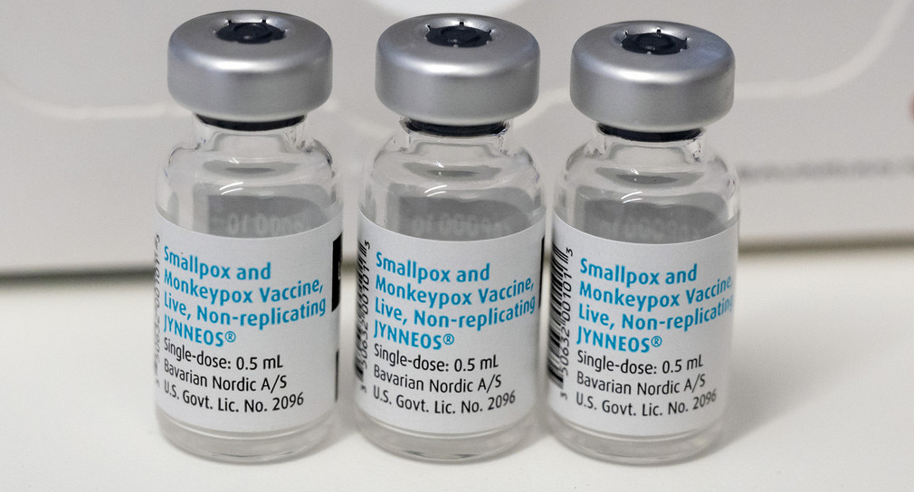 Drei leere Ampullen mit dem Impfstoff von Bavarian Nordic (Imvanex / Jynneos) gegen Affenpocken stehen auf einem Tisch.