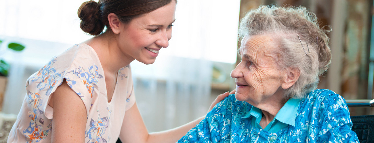 Junge Pflegerin mit Seniorin