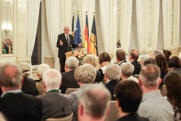 Tag des Ehrenamtes Kretschmann würdigt besonderes ehrenamtliches Engagement Ministerpräsident Winfried Kretschmann (hinten) bei seiner Ansprache zu den Gästen