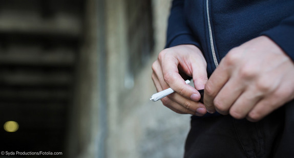 Mann hält Joint in der Hand