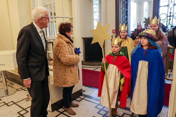 Aktion Dreikönigssingen Kretschmann empfängt Sternsingergruppen Ministerpräsident Winfried Kretschmann (links) und seine Ehefrau Gerlinde (zweite von links) begrüßen Sternsingerinnen und Sternsingern am Eingang der Villa Reitzenstein.