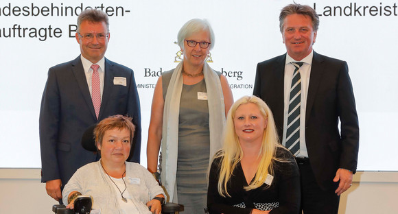 Gruppenfoto mit Ines Vorberg (Mitglied des Vorstands der LAG Selbsthilfe Baden-Württemberg e. V.), Landrat Dr. Achim Brötel (Vizepräsident des Landkreistags Baden-Württemberg), Oberbürgermeisterin a. D. Gudrun Heute-Bluhm (Vorstandsmitglied Städtetag Baden-Württemberg), Moderatorin Steffi Renz, Landes-Behindertenbeauftragte Stephanie Aeffner und Minister Manne Lucha