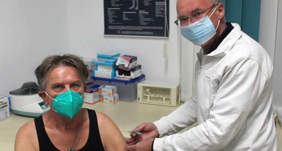 Minister Lucha wird von Dr. Jörg Schmid in Ravensburg gegen Grippe geimpft.