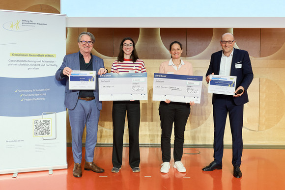 Preisverleihung des Präventionspreises: Minister Manne Lucha übergibt Scheck und Urkunde an Preisträger des Sonderpreises Stadt Mannheim und Bike Bridge e. V., Freiburg.