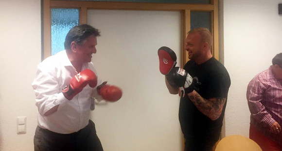 Minister Manne Lucha boxt mit einem Kickbox-Trainer beim Besuch des Projekts „Freizeit inklusive“ im Main-Tauber-Kreis.