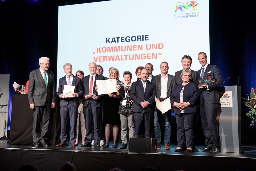 Gruppenbild aller Preisträger in der Kategorie „Kommunen und Verwaltungen“ auf der Bühne