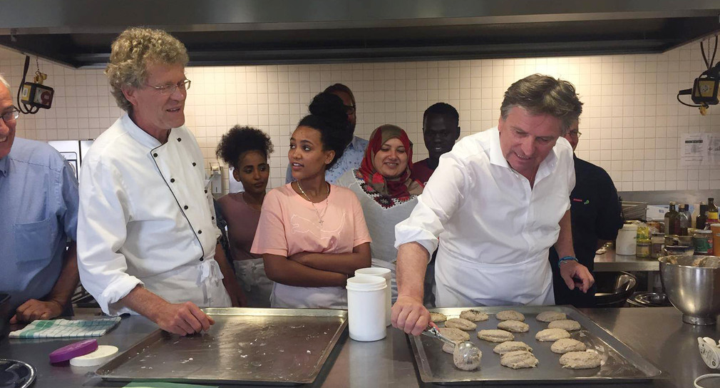 Minister Manne Lucha packt beim Ausbildungsprojekt „Cook Your Future“ in Heidelberg in der Küche mit an