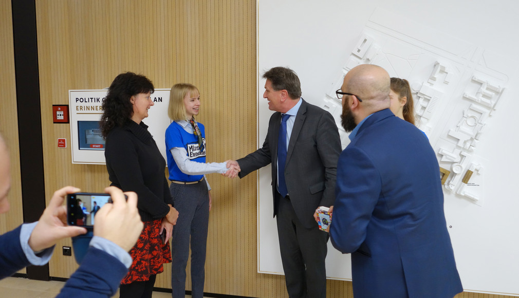 Minister Manne Lucha schüttelt Hand einer Schülerin im Medienzentrum des Landtags von Baden-Württemberg