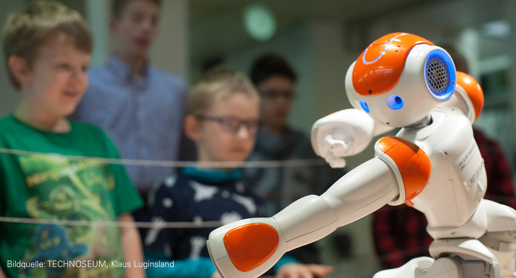 Kinder bestaunen Roboter Paul im Technoseum in Mannheim