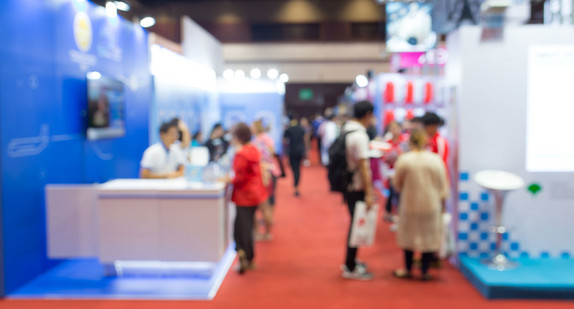 Besucher stehen an einem Messestand