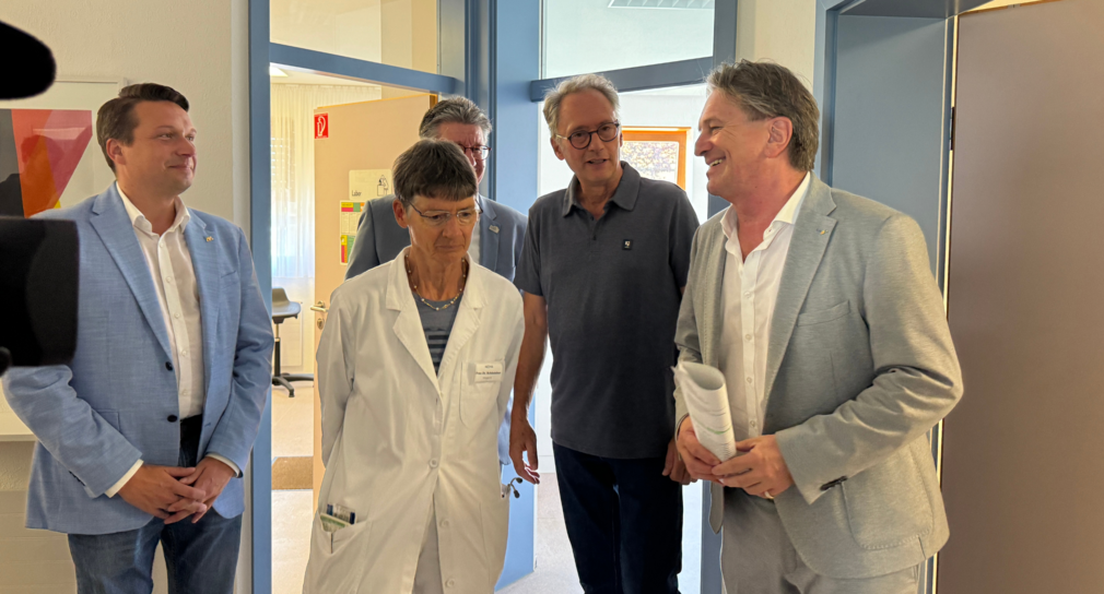 Minister Manne Lucha steht mit einer Ärztin und weiteren Mitarbeitenden im neuen Gesundheitszentrum in Hülben