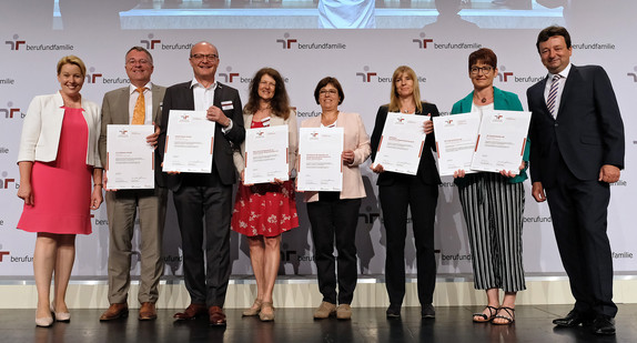 Gruppenfoto auf Bühne: Bundesfamilienministerin Dr. Franziska Giffey mit Vertreterinnen und Vertreter von sechs Arbeitgebern aus Baden-Württemberg und Bayern