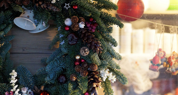 Weihnachtskranz hängt an Stand auf Weihnachtsmarkt