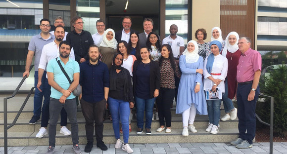 Gruppenbild vor Hauseingang von Minister Manne Lucha mit Verantwortlichen und Redaktionsmitgliedern der „tünews INTERNATIONAL“ in Tübingen