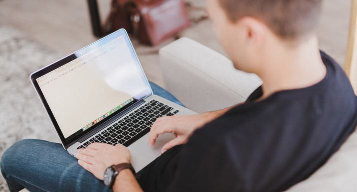 Mann arbeitet zuhause am Laptop