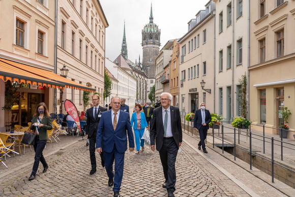 Reise Kretschmann besucht Sachsen-Anhalt Ministerpräsident Winfried Kretschmann (r.) mit Reiner Haseloff (l.), Ministerpräsident von Sachsen-Anhalt, bei einem Spaziergang durch die Altstadt Wittenbergs vor dem Turm der Schlosskirche (Bild: Staatsministerium Baden-Württemberg)