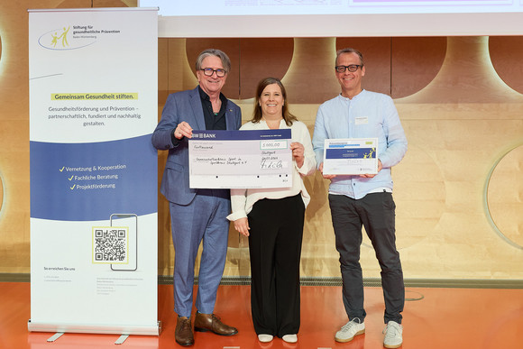 Preisverleihung des Präventionspreises: Minister Manne Lucha übergibt Scheck und Urkunde an Preisträger Gemeinschaftserlebnis Sport im Sportkreis Stuttgart e. V.
