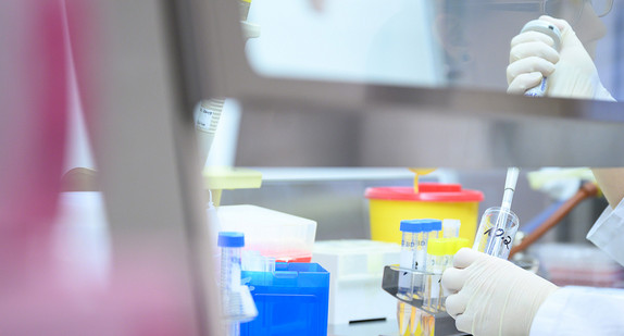 Frau in einem Labor zeigt Test für das neue Coronavirus