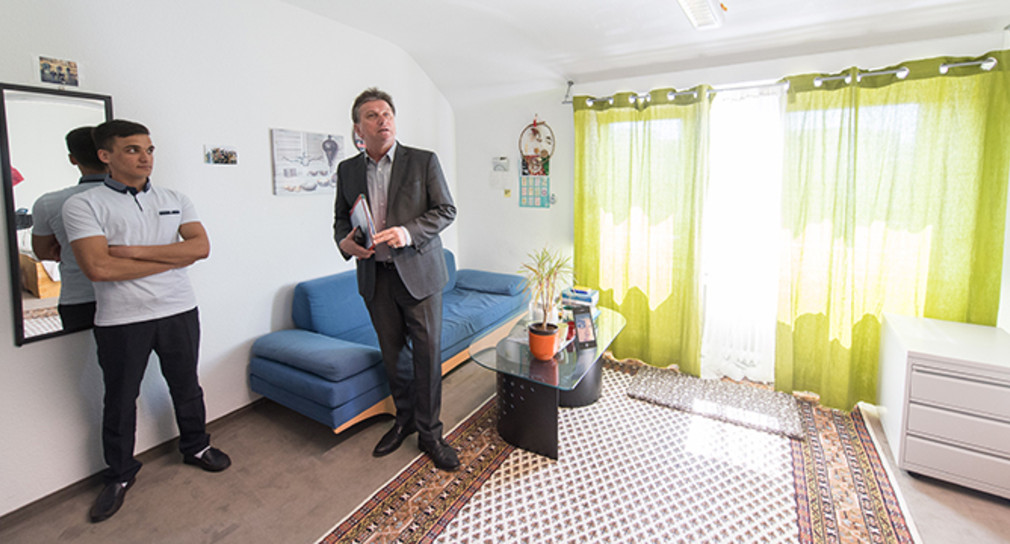 Minister Manne Lucha schaut sich während einem Besuch in einem Haus mit Wohngruppen für unbegleitete minderjährige Flüchtlinge das Zimmer eines Flüchtlings an. (Foto: © dpa)